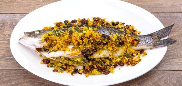 Сибас, запеченный с кедровыми орешками и изюмом