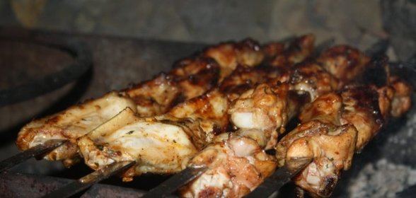 Куриные крылышки на шампурах на мангале в томатном маринаде