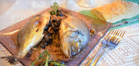 Дорадо, запеченная с вялеными томатами, маслинами и тимьяном на луковой подушке