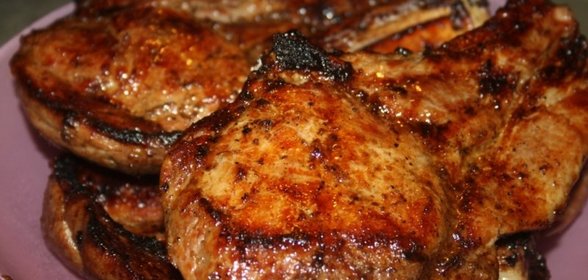 Сочные острые стейки рибай на мангале на решетке.